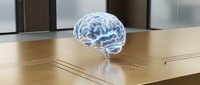 Transparent holographic human brain model floating above wooden desk surface in modern office environment for medical education and neuroscience presentations.