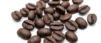 Roasted coffee beans scattered on white background, isolated for cafe branding, packaging design, and culinary projects.