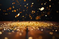 Golden glitter particles falling on reflective surface with bokeh effect and dark background, creating magical atmospheric composition.
