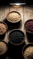Assorted legumes and grains in rustic bowls on wooden surface, including lentils, beans, and seeds for cooking and nutrition.
