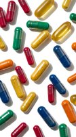 Colorful pharmaceutical capsules scattered on white background for medical and healthcare design projects.