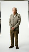Senior man with white hair and Caucasian ethnicity wearing a gray cardigan sweater and olive trousers, standing against white background for portrait and lifestyle use.