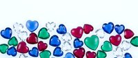 Colorful heart-shaped gems scattered on white background for romantic designs, jewelry concepts, Valentine's Day decorations and craft projects.