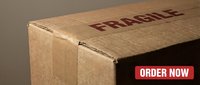 Cardboard shipping box with fragile label, close-up view of sealed corrugated package corner for delivery and logistics concepts.