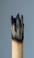 Burnt wooden pencil with charred tip showing fire damage and destruction concept for safety education and risk awareness materials.