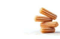 Stack of fresh churros with sugar coating on white background, traditional Spanish and Mexican pastry dessert isolated for culinary design.