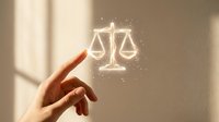 Hand pointing at glowing scales of justice symbol with light particles, representing legal services, law firm consultation, attorney advice, and judicial balance concepts.