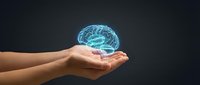 Hands holding glowing blue brain hologram representing artificial intelligence, neuroscience, mental health and cognitive technology concepts.