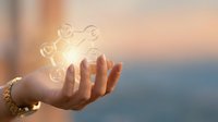 Young woman holding glowing light bulbs in palm against sunset sky, representing ideas, innovation, creativity, and sustainable energy solutions for business concepts.