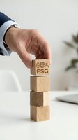 Businessman hand placing wooden block with ESG environmental social governance symbols on stack for sustainable business strategy and corporate responsibility.