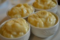 Creamy macaroni and cheese served in individual white ceramic bowls, showcasing rich, melted cheddar sauce coating tender pasta shells for comfort food dining.
