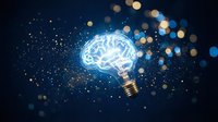 Glowing brain lightbulb with sparkling particles on dark blue background representing creativity, innovation and bright ideas for business concepts.
