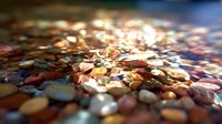 Colorful wet pebbles with shallow depth of field creating bokeh effect, smooth stones in various earthy tones glistening with water.