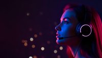 Young woman with headphones in profile against dark background with colorful neon lighting and bokeh effects for music and entertainment concepts.