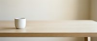Minimalist wooden table with white ceramic cup on light neutral background, suitable for interior design, home decor, and lifestyle marketing projects.