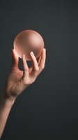 Male hand holding glowing pink sphere against dark background. Conceptual lighting effect for technology, innovation and creative design projects.