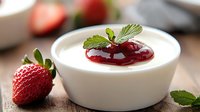 Creamy white yogurt bowl with fresh strawberry and red berry jam topping, garnished with mint leaves on wooden surface, macro food photography.