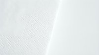 White textured fabric with diagonal fold creating shadow contrast, suitable for backgrounds, textile design, and minimalist compositions.