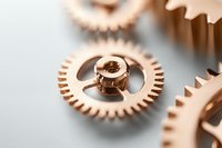 Copper-plated mechanical watch gears and cogs in macro view showing precise engineering details against blurred background. Demonstrates luxury watchmaking craftsmanship.