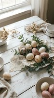 Rustic Easter table setting with naturally dyed eggs, eucalyptus branches and dried flowers on weathered white wood surface for spring holiday celebration.