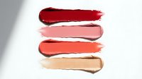 Colorful lipstick swatches in red pink coral and nude tones on white background for makeup beauty cosmetics branding and fashion design projects.