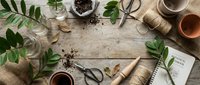 Gardening workspace with potted plants, tools, seeds and notebook on rustic wooden table. Perfect for spring planting, botanical projects and organic gardening concepts.