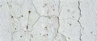 Cracked white painted wall surface showing weathered texture with peeling paint and natural aging patterns for vintage design projects.