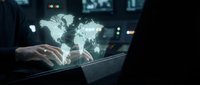 Businessman using laptop with glowing world map hologram for global business, international trade, and digital connectivity solutions.
