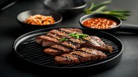 Grilled Korean beef short ribs with sesame seeds and fresh herbs on black plate, served with kimchi and spicy sauce on dark moody background.