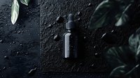 Dark moody composition with essential oil dropper bottle against black textured background with water drops and green leaves, creating dramatic atmosphere.