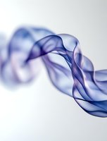Ethereal blue smoke swirls creating elegant curves and waves against white background, with delicate transparency and flowing movement patterns suitable for abstract designs.
