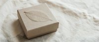 Handmade natural soap bar with embossed leaf pattern on organic linen fabric background for eco-friendly skincare and sustainable beauty products.