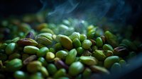 Fresh roasted pistachios with smoke rising against dark background, vibrant green nuts with cracked shells in dramatic lighting, macro food photography.