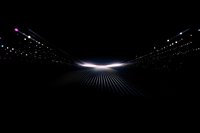Futuristic glowing light path with purple and blue dots forming perspective lines against black background, creating depth and motion effect.