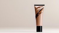 Luxurious cosmetic tube with rose gold metallic finish and black abstract brush strokes on beige background. Elegant packaging design for foundation or cream product.