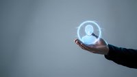 Digital user profile icon glowing in hand against gray background, representing online identity, account management, and virtual networking for business and technology applications.