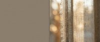 Close-up of natural linen fabric texture with warm sunlight filtering through, creating soft shadows and highlights. Suitable for home decor, textile design, and interior styling projects.