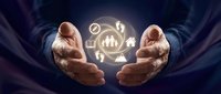 Businessman in dark suit holding glowing financial icons and growth charts between cupped hands, representing business success, investment strategy, and data analytics.
