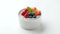 Chia seed pudding topped with fresh berries and mint in white ceramic bowl on clean background for healthy breakfast recipes and superfood content.