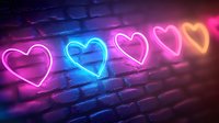 Glowing neon heart signs in pink, blue and orange colors on dark brick wall background create romantic urban atmosphere for Valentine's day design and love concepts.