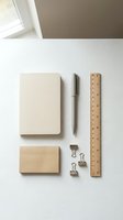 Minimalist office supplies flat lay with kraft paper notebooks, wooden ruler, pen and metal binder clips on white desk surface for branding mockup.