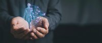 Businessman hands holding glowing digital brain with neural network connections representing artificial intelligence and machine learning technology concepts.