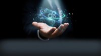 Businessman hands holding glowing atomic structure with particles and light effects representing science, technology innovation and molecular research concepts.