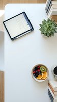 Tablet with blank screen on white desk next to succulent plant and fresh fruit bowl, ideal for web design, app mockups, and digital workspace concepts.