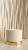 Elegant cream marble cylinder podium with gold base against beige curtain backdrop for luxury product display and branding presentations.