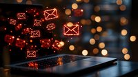 Glowing red email icons float above laptop keyboard with bokeh lights background creating magical digital communication concept for marketing campaigns.
