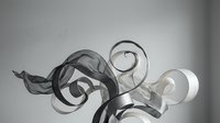 Abstract flowing ribbons in black and white creating elegant swirls and curves against gradient background for modern graphic design projects.