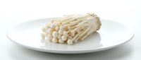 Enoki mushrooms isolated on white plate, ready for culinary design, food photography, recipe blogs, restaurant menus, cooking websites.