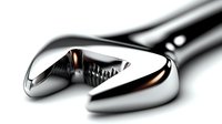 Closeup of adjustable chrome wrench with dramatic lighting and reflective metallic surface showing professional grade tool detail and craftsmanship.