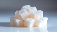 White sugar cubes stacked in pyramid formation on reflective surface with soft lighting, showcasing crystalline texture and delicate shadows for food and beverage concepts.